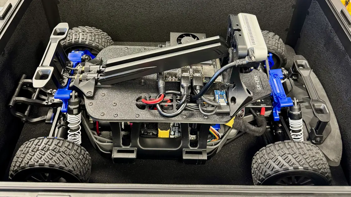A GOAT Racer 3 seen from above in its hard case, with its Jetson Orin Nano, antennas and depth camera mounted on the chassis