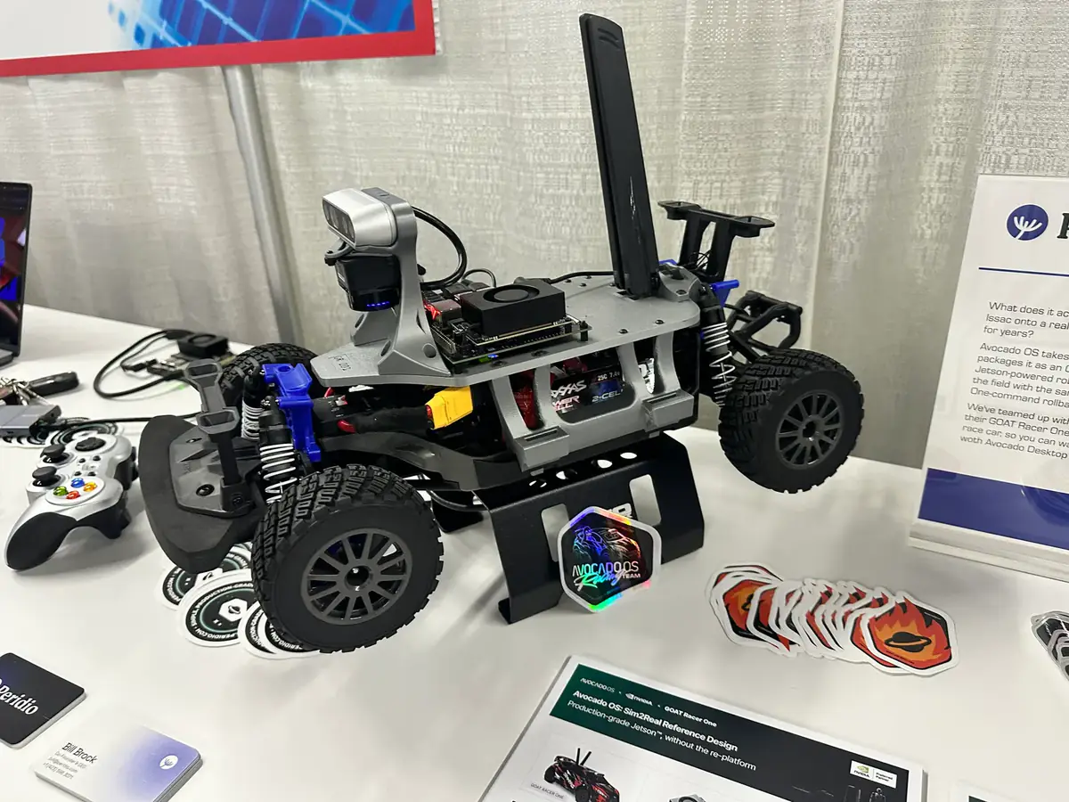 A GOAT Racer 3 car on a stand, showing its Jetson module, depth camera and antenna, with an Avocado OS Racing Team sticker